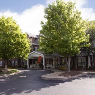 A building entrance surrounded by trees on a sunny day.