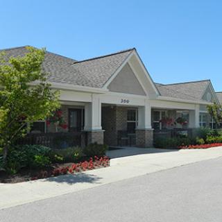 A well-maintained commercial building with a landscaped entrance on a clear day.