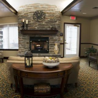 A cozy living room with a central fireplace and comfortable seating.
