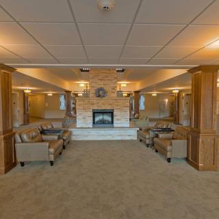 A cozy living room with a central fireplace and comfortable seating arrangements.