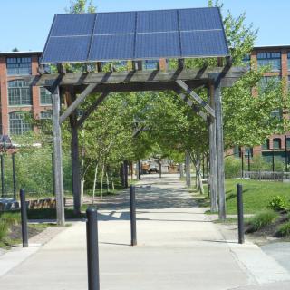A pedestrian walkway in an urban park featuring solar panels for sustainable energy.