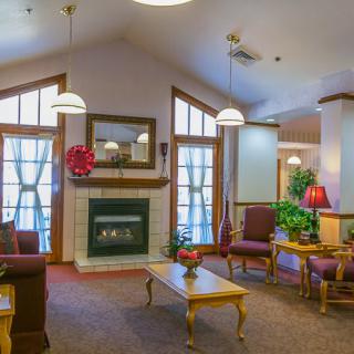 A cozy living room with a fireplace, comfortable seating, and plenty of natural light.