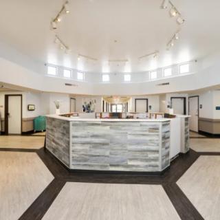 A modern reception area featuring a central desk with bright lighting and contemporary design elements.