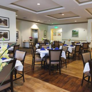 A neatly arranged restaurant dining room with tables set for service.