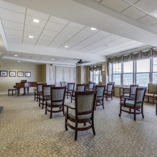 A well-lit conference room with arranged chairs and large windows.