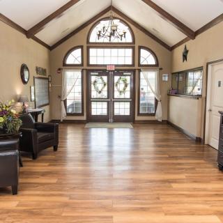 A spacious lobby with wooden flooring and decorative elements.