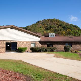 A peaceful facility surrounded by nature under a clear blue sky.