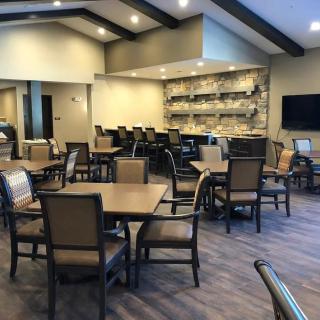 Modern dining area with tables, chairs, and a bar.