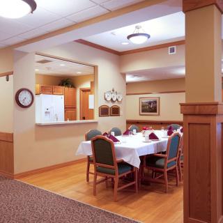 A cozy dining area with a set table and chairs under warm lighting.