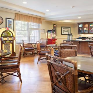 A cozy retro-themed dining area featuring a jukebox and wooden furniture.