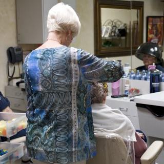 A hairdresser working on a client's hair in a salon.