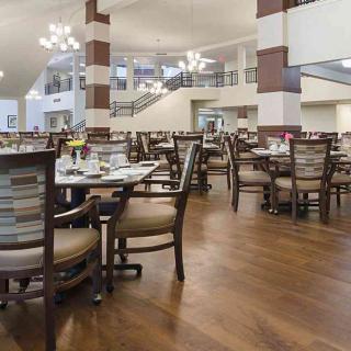 An elegantly designed restaurant dining area with wooden floors and chandeliers.