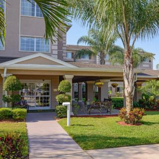 A well-maintained residential building surrounded by palm trees and lush landscaping.