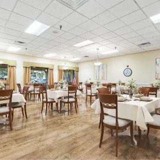 A spacious dining area featuring neatly arranged tables and chairs with a warm ambiance.