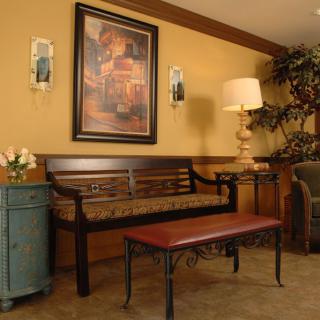 A cozy waiting area with a wooden bench, artwork on the wall, and ambient lighting.