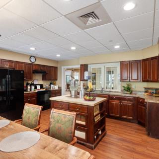 A spacious kitchen with wooden cabinets, an island counter, and dining area.