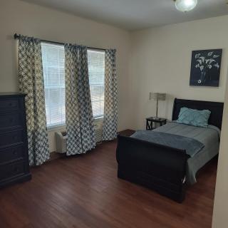 A neatly arranged bedroom with a single bed and a dresser.