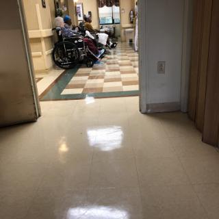 A view of a hospital hallway with patients and wheelchairs.