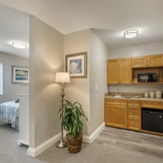 A compact apartment interior featuring a kitchen area, bedroom, and tasteful decor.