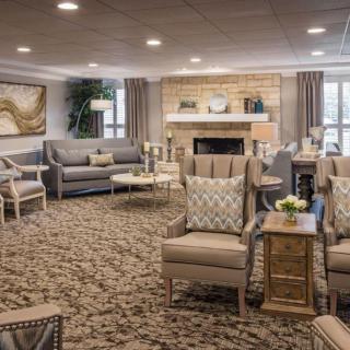 A cozy and elegantly designed living room with a fireplace, featuring comfortable seating and warm lighting.