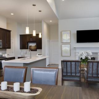 A modern open-concept kitchen and dining area with stylish furnishings and contemporary lighting.