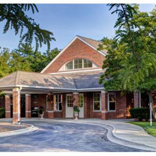 A welcoming entrance to a brick building surrounded by greenery.
