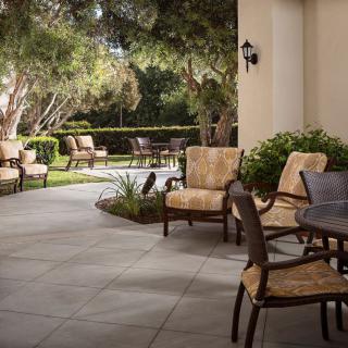 A tranquil patio area with comfortable seating surrounded by lush greenery.
