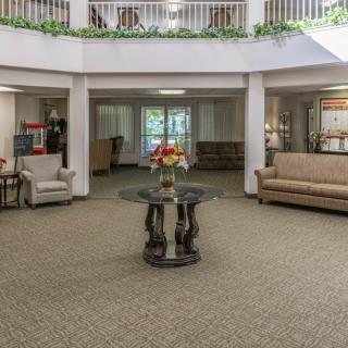A spacious lobby area with comfortable seating and a central coffee table adorned with flowers.
