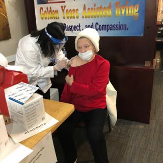 A healthcare professional administering a vaccination to an elderly individual at a community clinic.