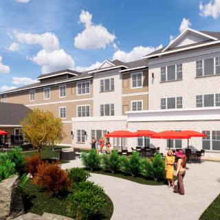 A modern building with people enjoying a sunny day on the landscaped patio.