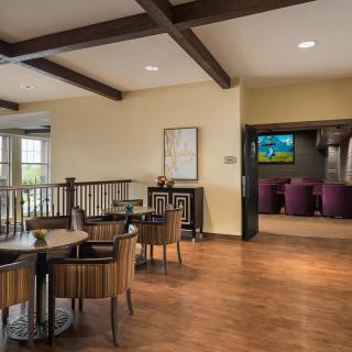 A modern lounge area featuring wooden floors, comfortable seating, and a television.