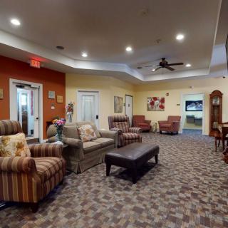 A cozy lounge area with comfortable sofas and armchairs, a coffee table, and warm lighting.