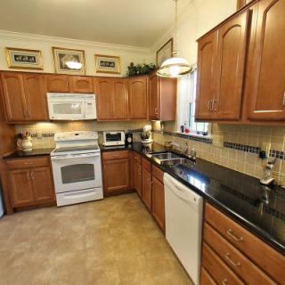A modern kitchen with wood cabinets and granite countertops.
