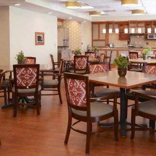 A spacious dining area with wooden furniture and a view of the kitchen.