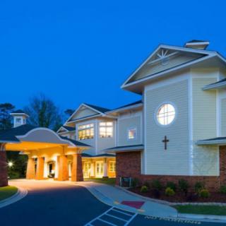 A beautifully lit building with a prominent cross at night.