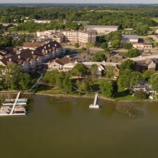 A picturesque aerial view of a lakeside resort surrounded by lush greenery.
