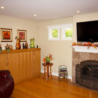 A cozy living room featuring a fireplace, modern TV, and decorative elements.