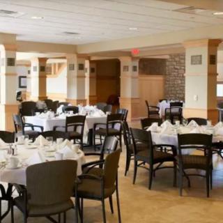 A formal dining room with tables set for guests.