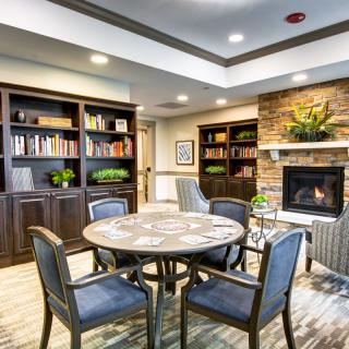 A cozy reading room with bookshelves and a fireplace.