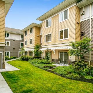 A view of a residential apartment complex with well-maintained lawns and greenery.