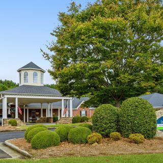 A scenic view of a building surrounded by lush greenery and well-maintained landscaping.