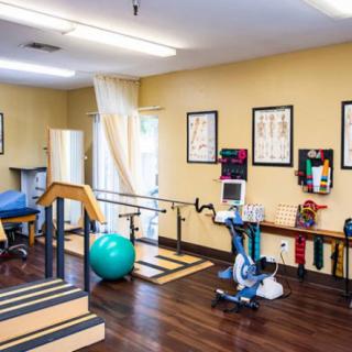 A well-equipped physical therapy room featuring various exercise and rehabilitation equipment.