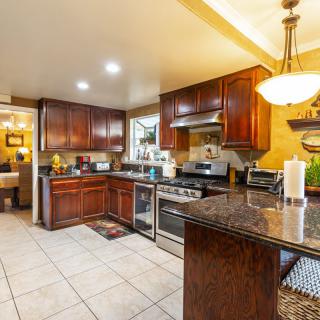 A modern kitchen with wooden cabinets and granite countertops.