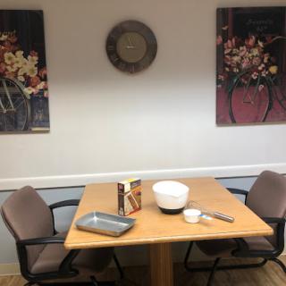 A cozy dining area featuring a table set with kitchenware and adorned with decorative wall art.