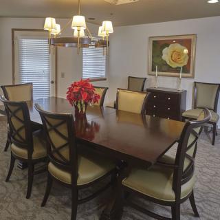 A well-decorated dining room featuring a wooden table, elegant chairs, and a chandelier overhead.