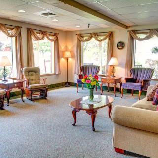 A cozy and well-furnished living room with sofas, chairs, and tables arranged in a welcoming setting.