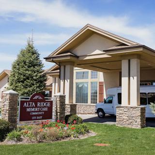 A welcoming entrance to a residential facility with a van parked nearby.