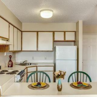 A compact kitchen with a dining area featuring two chairs and a countertop.