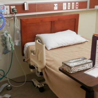 A hospital room with a bed and medical equipment.