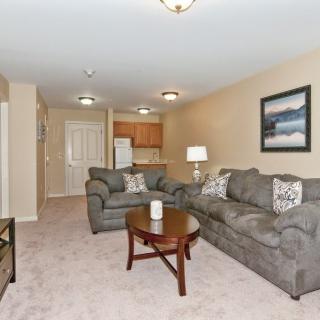 A cozy living room with comfortable sofas, a wooden coffee table, and decorative artwork on the wall.